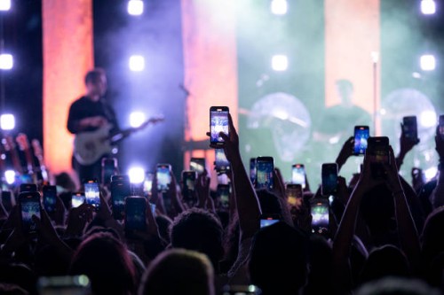 Concert-goers record and take photos with their smartphones during the Joshua Bassett concert at the Bataclan on May 4, 2023 in Paris, France.