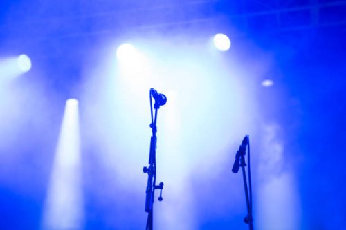 concert microphones on a concert stage under blue and white spotlights - concert stock pictures, royalty-free photos & images