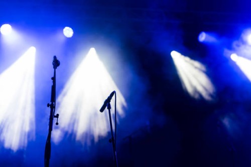 concert microphones stands on a blue stage under spotlights - concert stock pictures, royalty-free photos & images