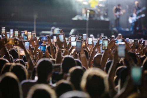Concertgoers record videos and take photos with their smartphones as Jonas Brothers perform live on stage during a concert on April 16, 2024 in Sao...