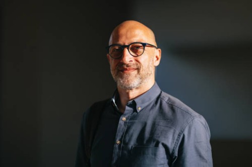 confident businessman smiling in sunlit urban environment - fashion stock pictures, royalty-free photos & images