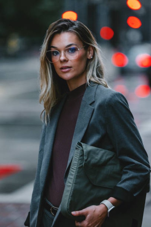 confident businesswoman standing on city street at dusk - fashion stock pictures, royalty-free photos & images
