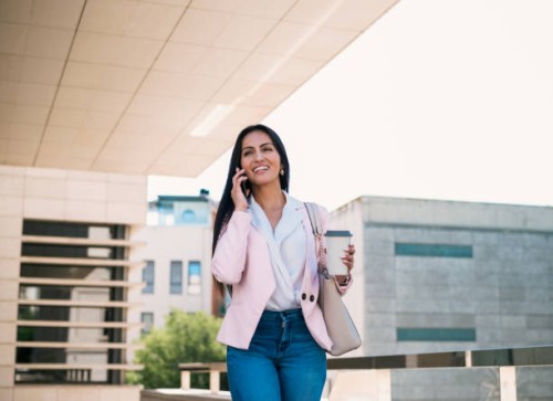 confident businesswoman with takeaway coffee speaking on smartphone on street - junk food stock pictures, royalty-free photos & images