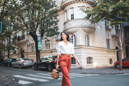 confident woman strolling through scenic urban neighborhood street - fashion stock pictures, royalty-free photos & images