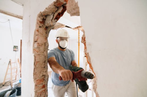 construction worker demolishing a brick wall - home decoration stock pictures, royalty-free photos & images