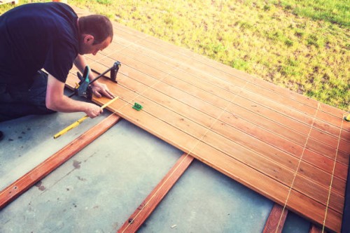 construction worker screwing down wood deck with battery power screw gun or drill. - home decoration stock pictures, royalty-free photos & images