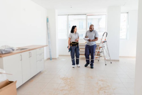construction workers analyzing blueprints in the apartment - home decoration stock pictures, royalty-free photos & images
