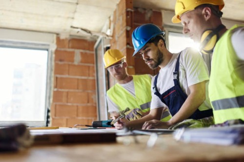 construction workers analyzing blueprints while working at construction site. - home decoration stock pictures, royalty-free photos & images