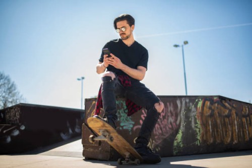 cool guy with sunglasses and smart phone, relaxing at city skate park stock photo - fashion stock pictures, royalty-free photos & images