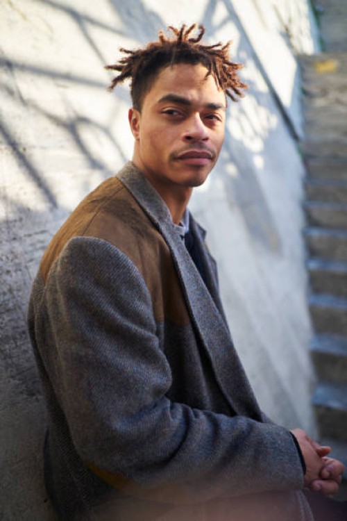 cool looking man looking off camera leaning against a wall - fashion stock pictures, royalty-free photos & images