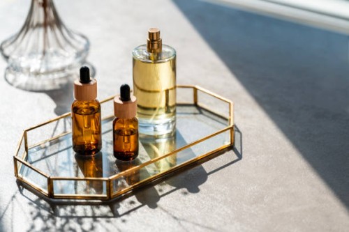 cosmetic products and mirror on table. unrecognizable bottles of perfume and samplers. beauty concept - home decoration stock pictures, royalty-free photos & images