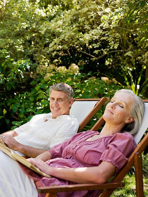 couple assis sur des chaises longues sur le jardin - garden decoration photos et images de collection