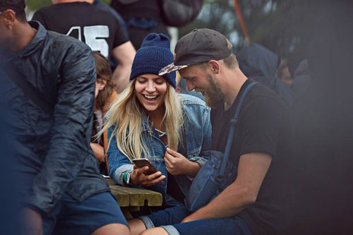 couple checking phone at festival - concert stock pictures, royalty-free photos & images