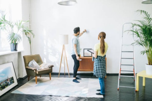 couple choosing the right color for their walls - home decoration stock pictures, royalty-free photos & images