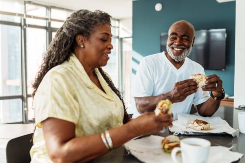 couple de personnes âgées afro-américaines prenant leur petit-déjeuner dans une chambre d’hôtel pendant leurs vacances - food photos et images de collection