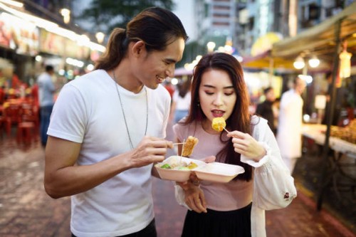 couple eating dumplings at a night market - food stock pictures, royalty-free photos & images