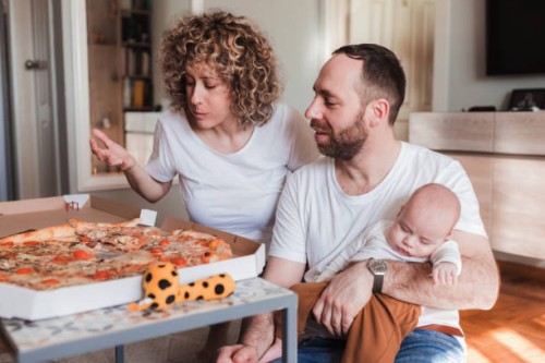 couple eating pizza when the baby is sleeping - junk food stock pictures, royalty-free photos & images