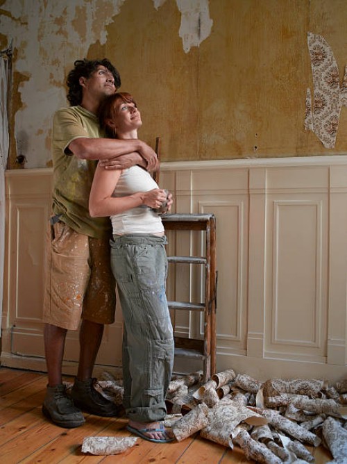 couple embracing looking at half decorated room - home decoration stock pictures, royalty-free photos & images