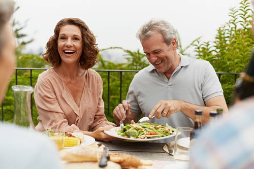 couple enjoying outdoor lunch with friends - food stock pictures, royalty-free photos & images