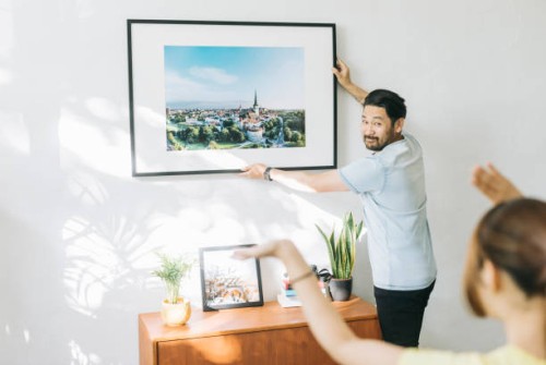 couple hanging new picture to their loft - home decoration stock pictures, royalty-free photos & images