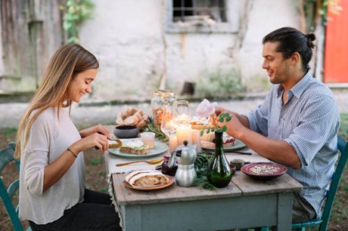 couple having a romantic candelight meal next to a cottage - garden decoration stockfoto's en -beelden