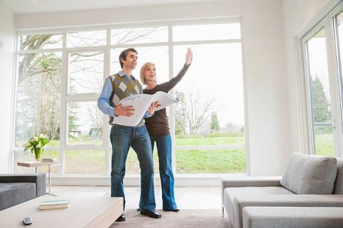 couple holding building plans and discussing remodel - home decoration stock pictures, royalty-free photos & images