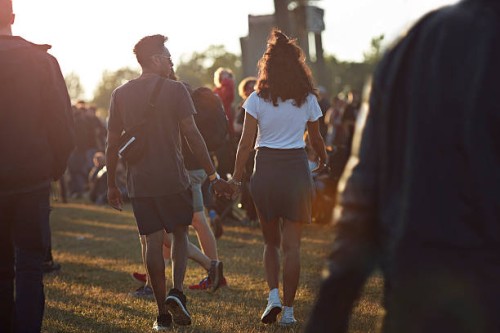 couple holding hands at big festival - concert stock pictures, royalty-free photos & images