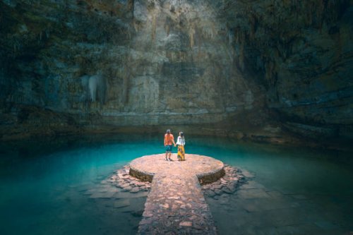 couple holding hands exploring a cenote in yucatan peninsula, mexico - travel photos et images de collection