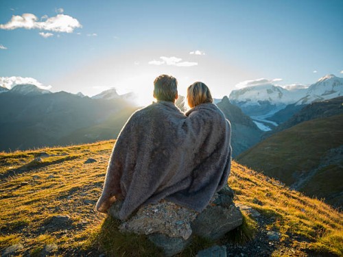 couple huddle in blanket, watch mountain sunrise - travel stock-fotos und bilder