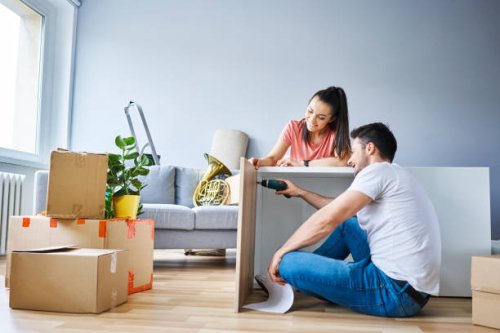couple in new apartment assembling furniture together - home decoration stock pictures, royalty-free photos & images