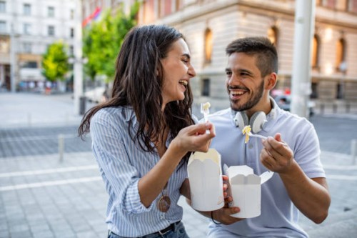 couple in the city eating fast food - junk food stock pictures, royalty-free photos & images