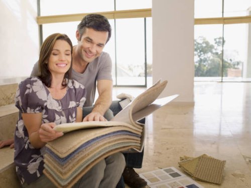 couple looking at carpet samples in empty house - home decoration stock pictures, royalty-free photos & images