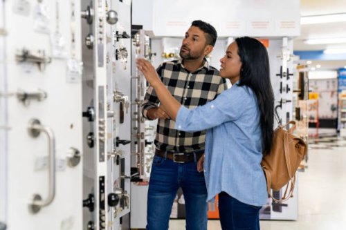 couple looking at security locks for their house at a hardware store - home decoration stock pictures, royalty-free photos & images