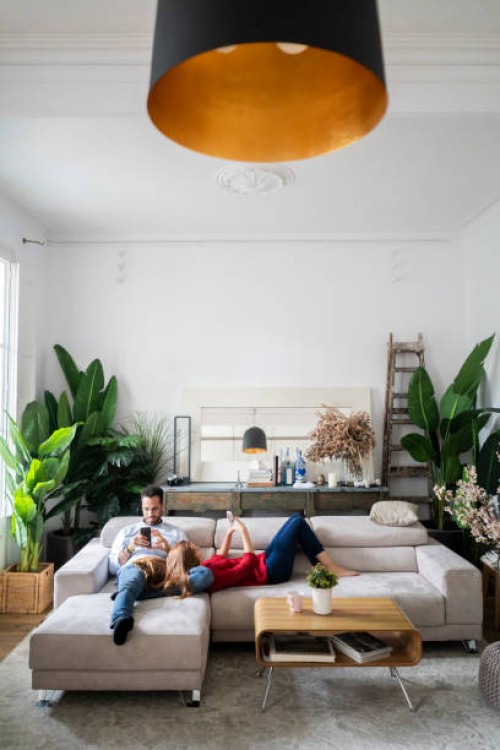 couple lying on couch, using heir smartphones - home decoration stock pictures, royalty-free photos & images