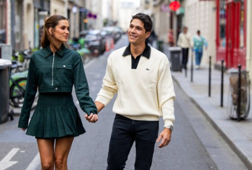 Couple Maria Pombo wears green jacket, pleated skirt & Pablo Castellano wears beige sweater outside Lacoste during Womenswear Spring/Summer 2025 as...