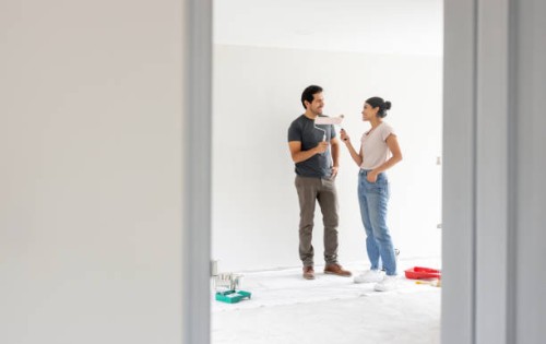couple painting a wall together while renovating their house - home decoration stock pictures, royalty-free photos & images