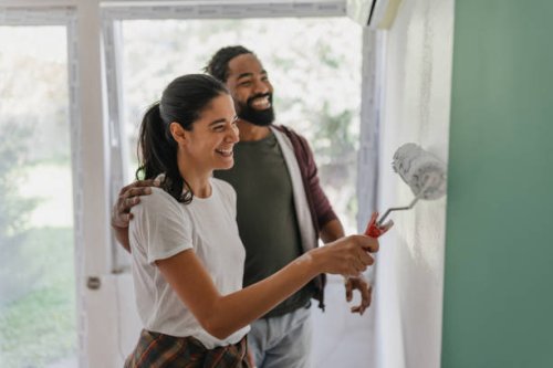 couple painting together in a bright and happy space - home decoration stock pictures, royalty-free photos & images