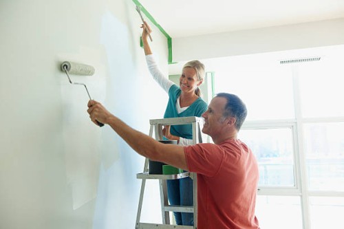 couple painting wall together - home decoration stock pictures, royalty-free photos & images