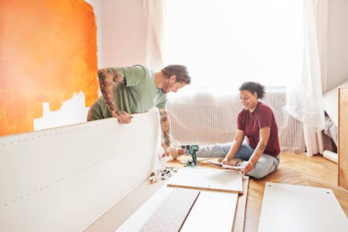 couple positioning planks during home renovation - home decoration stock pictures, royalty-free photos & images