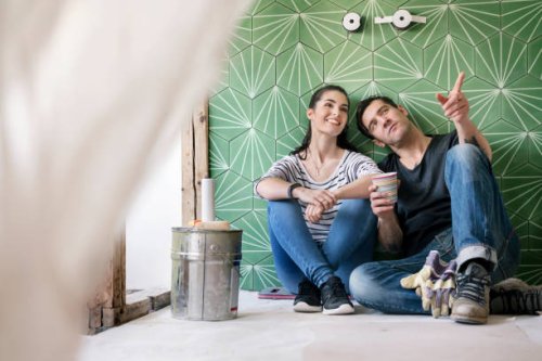 couple renovating new house, sitting on ground planning bathroom - home decoration stock pictures, royalty-free photos & images