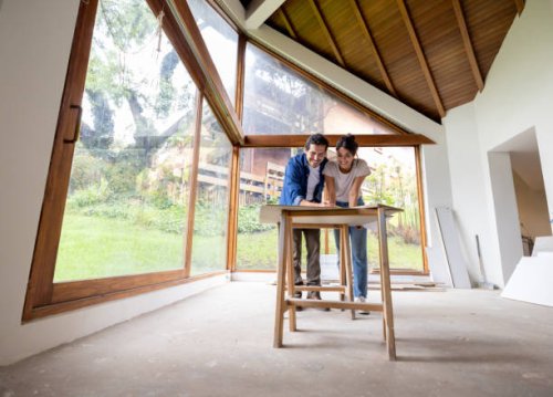 couple renovating their house and looking at the blueprints - home decoration stock pictures, royalty-free photos & images
