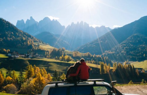 couple sit on car rooftop looking at mountains in the distance - travel stock-fotos und bilder