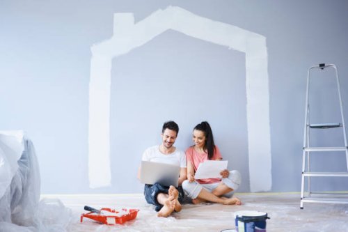 couple sitting in new apartment using laptop - home decoration stock pictures, royalty-free photos & images