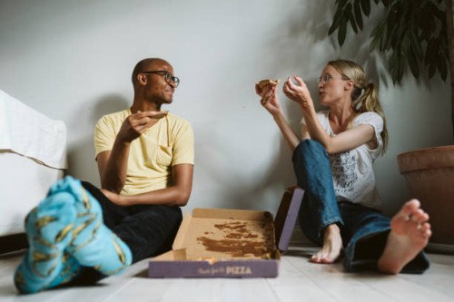 couple sitting on floor and having pizza - junk food stock pictures, royalty-free photos & images