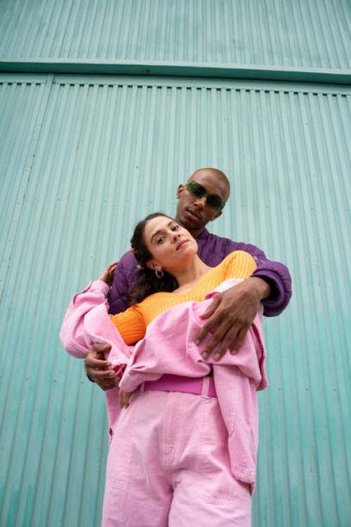 couple standing together in front of blue shutter door - fashion stock pictures, royalty-free photos & images