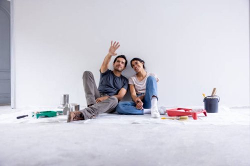 couple taking a break from painting their house - home decoration stock pictures, royalty-free photos & images
