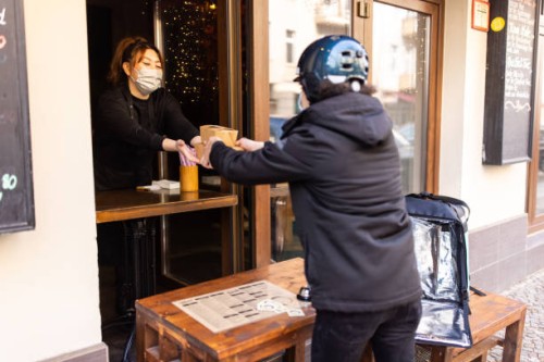 courier person taking food packets from restaurant for delivery. - junk food stock pictures, royalty-free photos & images