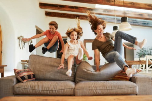 course pour la meilleure place sur le canapé. mère et enfants sautant. - home decoration photos et images de collection