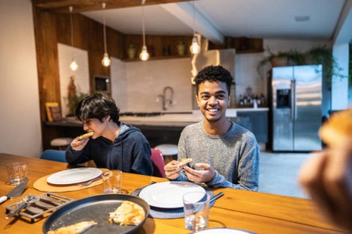 cousin having pizza together in family at home - junk food stock pictures, royalty-free photos & images