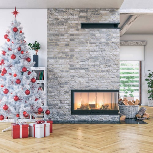 cozy, luxurious, and modern living room with a white christmas tree, gifts, a lit fireplace, windows, with decoration - home decoration stock pictures, royalty-free photos & images